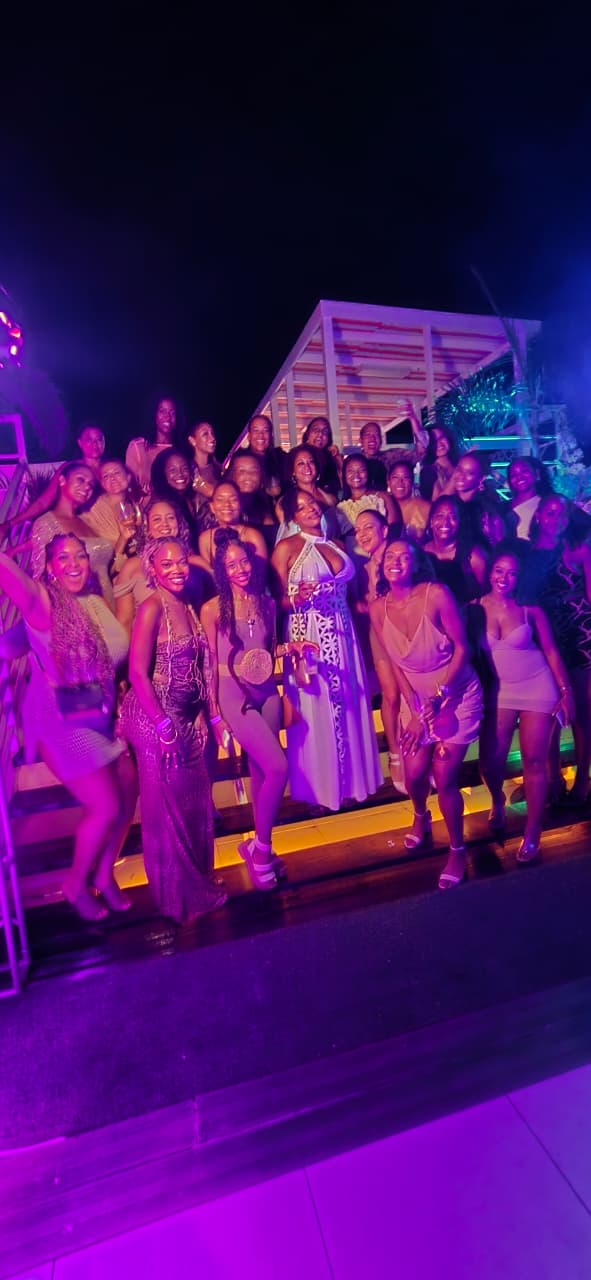 A dressed-up crew posing under purple party lights on a Mowatt Tours night out